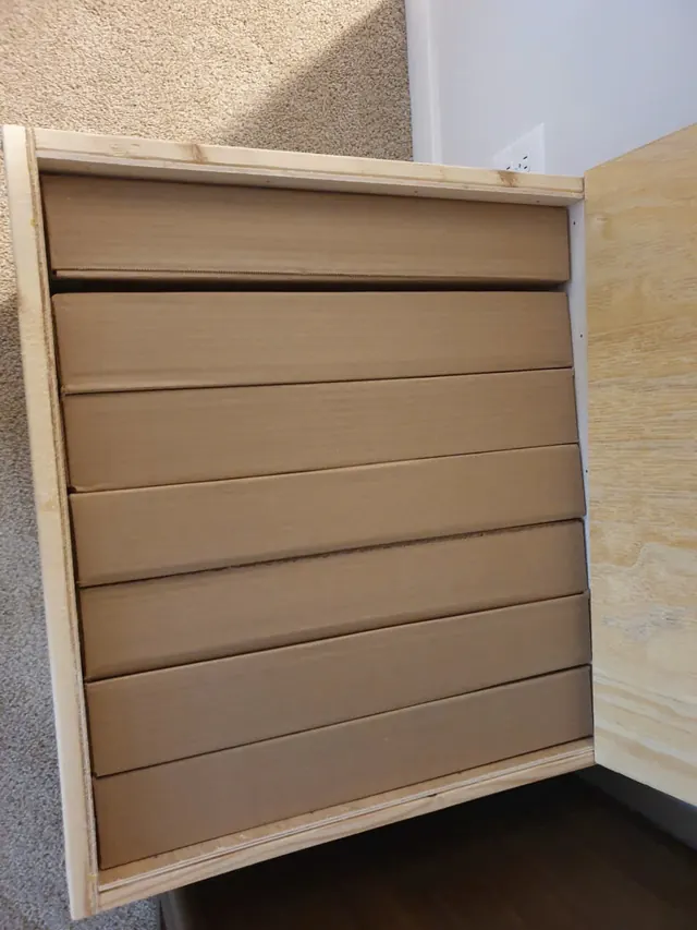 Cardboard cartons arranged inside an open wooden crate